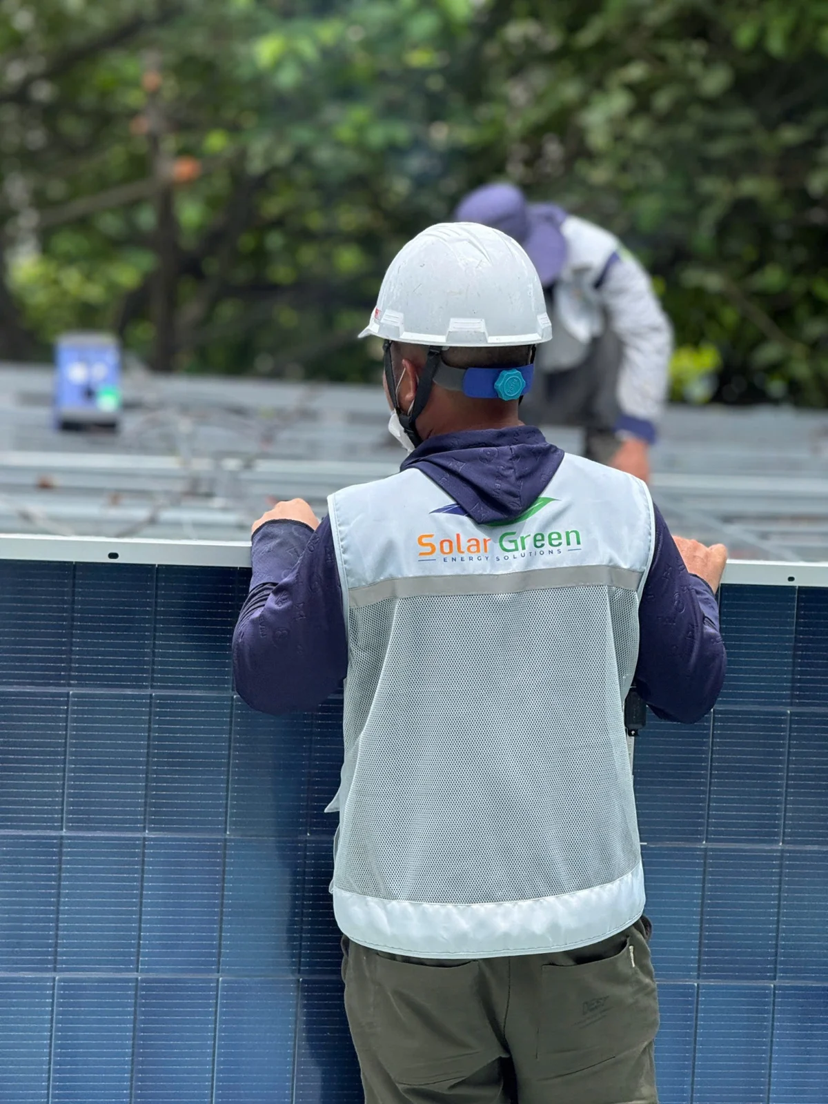 Kỹ thuật viên mặc áo Solar Green lắp đặt tấm pin